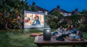 Easy-to-install garden cinema projector screen illuminated by a bright battery-powered projector at dusk.