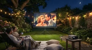 Illuminated garden cinema projector screen showing a film under the night sky.