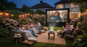 Friends gathered in a British garden watching a movie on a large outdoor cinema projector screen