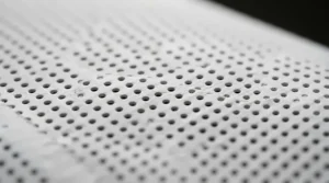 A close-up view of the perforation pattern on an acoustically transparent projector screen texture