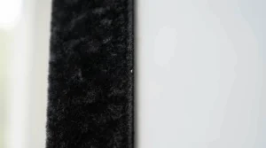 A detailed shot showing the light-absorbing velvet-wrapped border of a premium fixed frame projector screen.