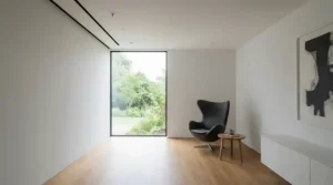 A retractable motorised 8K projector screen seamlessly blending into a minimalist architectural interior.