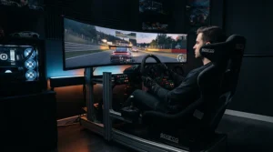 An immersive gaming setup featuring a wide curved projector screen displaying a high-speed racing simulator